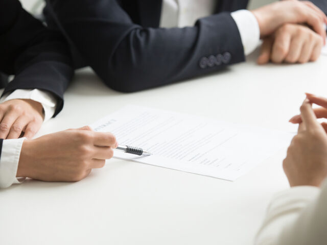 Negotiations about contract terms concept, hand pointing at docu